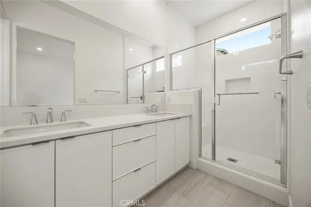 a bathroom with a shower sink and mirror