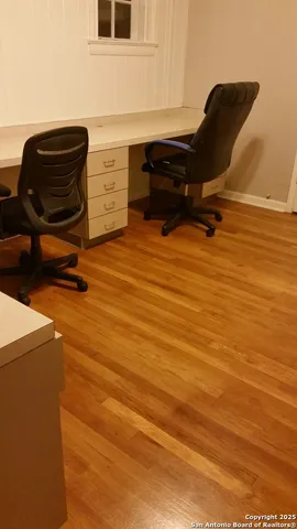 a view of a workspace with furniture and wooden floor