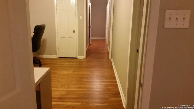 a view of a hallway with wooden floor