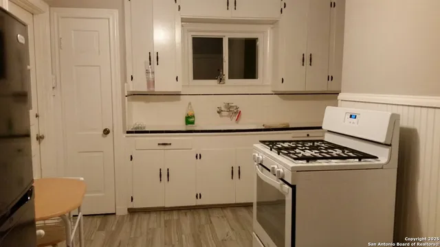 a kitchen with granite countertop white cabinets and white appliances