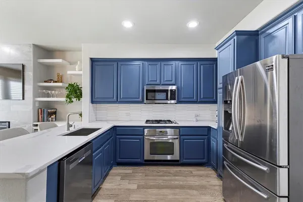 a kitchen with kitchen island granite countertop stainless steel appliances and wooden cabinets