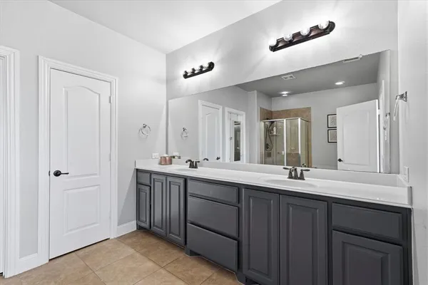 a bathroom with a double vanity sink and mirror