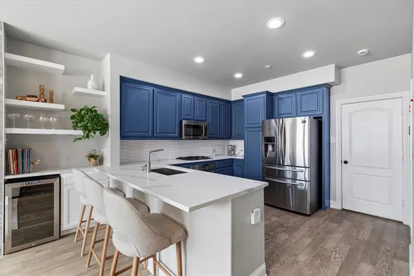a kitchen with a refrigerator a stove a sink and cabinets