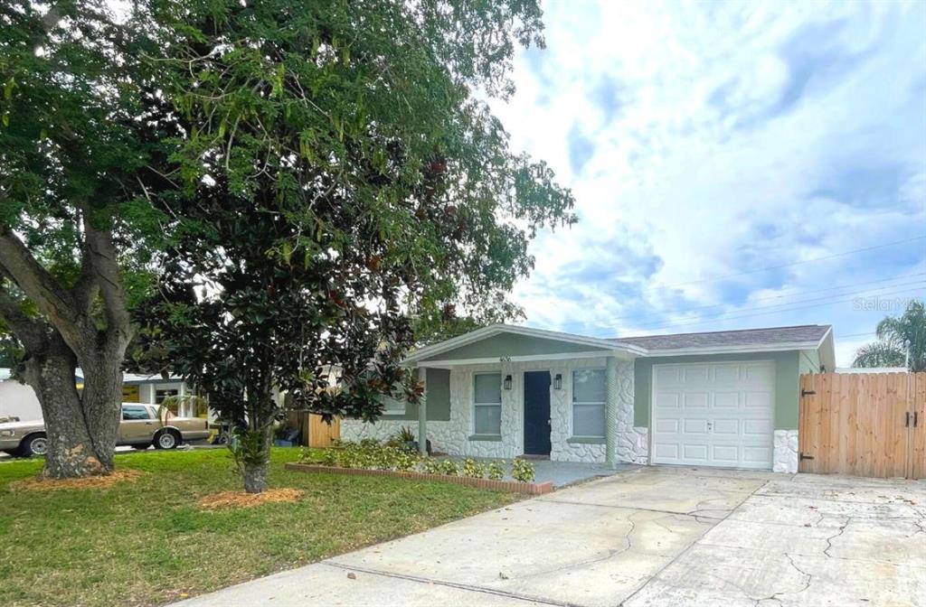 4636 Irene Loop, Unit 1 New Port Richey, FL 34652 - Photo 1 of 11 a front view of a house with a garden and trees