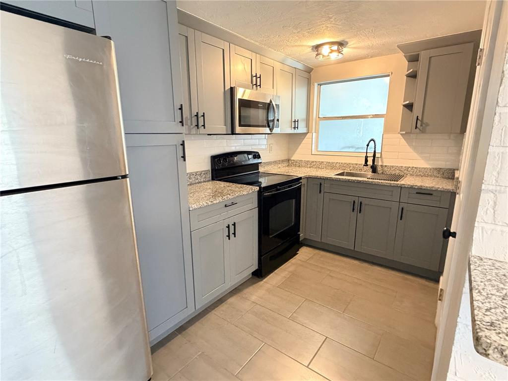 4636 Irene Loop, Unit 1 New Port Richey, FL 34652 - Photo 5 of 11 a kitchen with a refrigerator sink and microwave