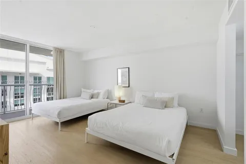 a bedroom with two beds and windows
