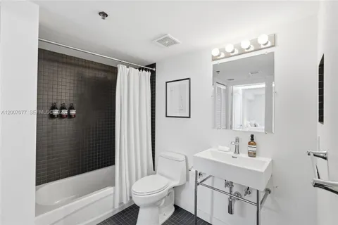 a bathroom with a sink toilet a mirror and shower