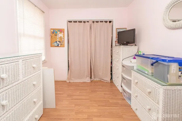 a bedroom with a bed and a flat tv screen on the dresser