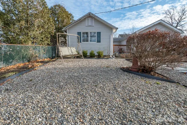 a view of a house with a yard and large trees
