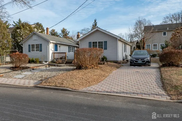 a front view of a house with cars