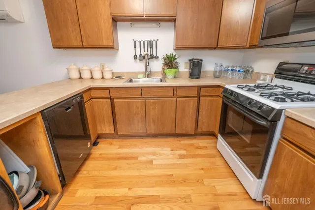 a kitchen with a sink a stove top oven and cabinetry
