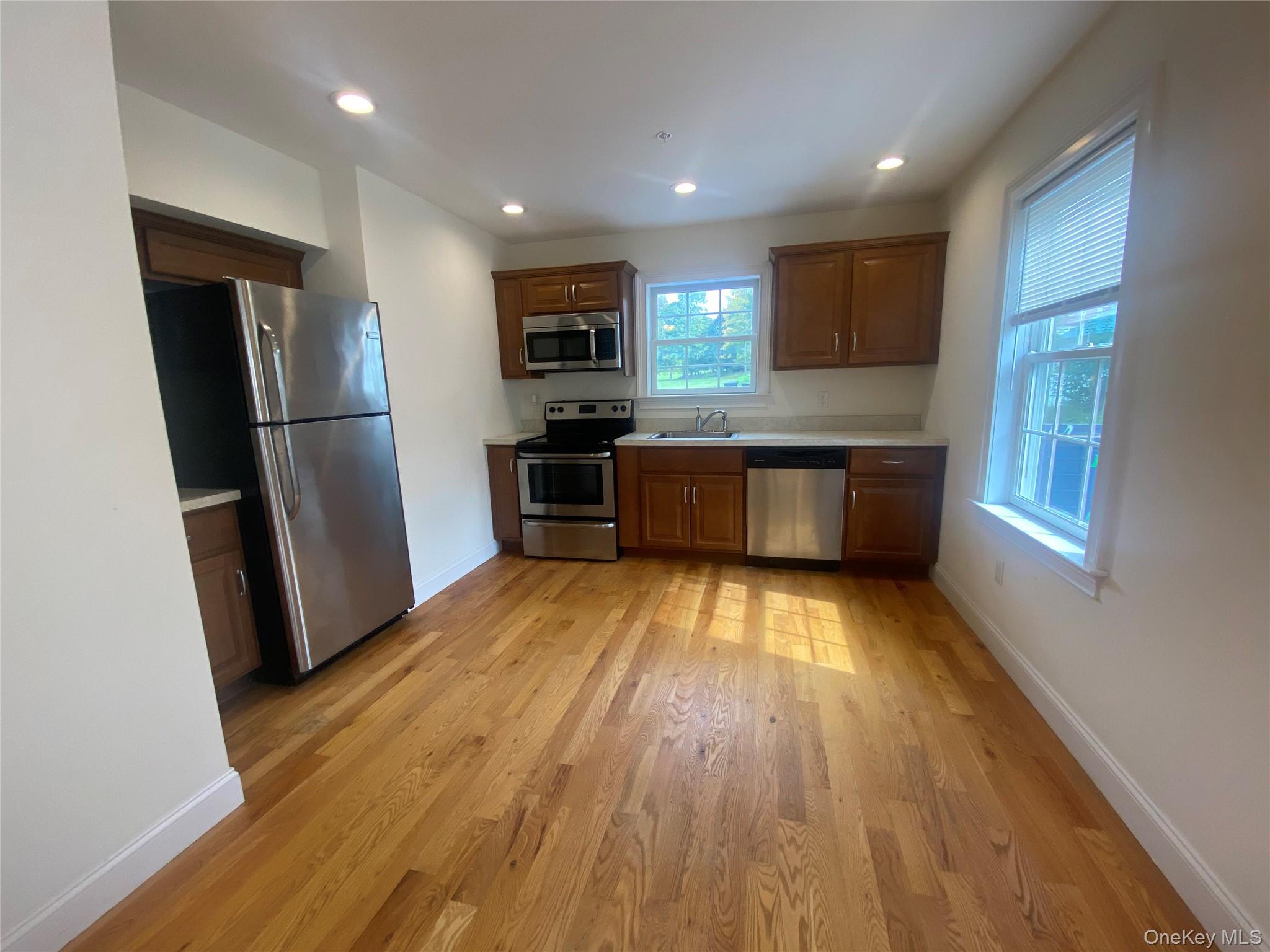 27 North Main Street Florida, NY 10921 - Photo 16 of 20 Kitchen featuring light countertops, appliances with stainless steel finishes, light wood-style floors, recessed lighting, and brown cabinetry