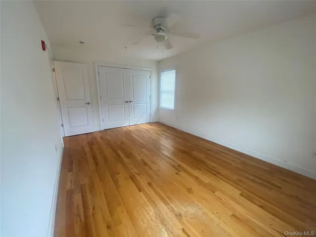 a big room with wooden floor and windows in a room