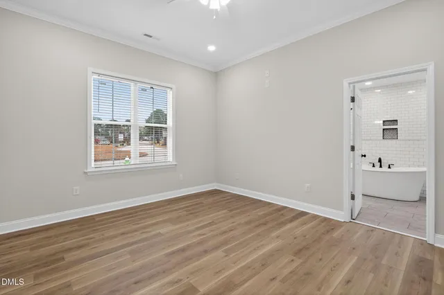 a view of a big room with wooden floor and windows