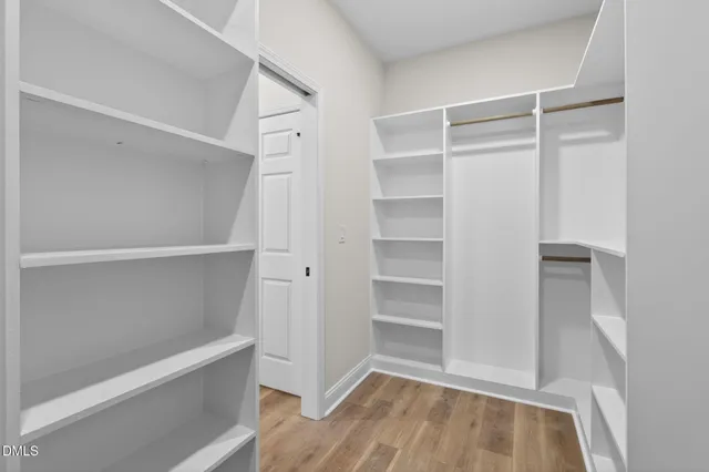 a view of walk in closet with empty racks