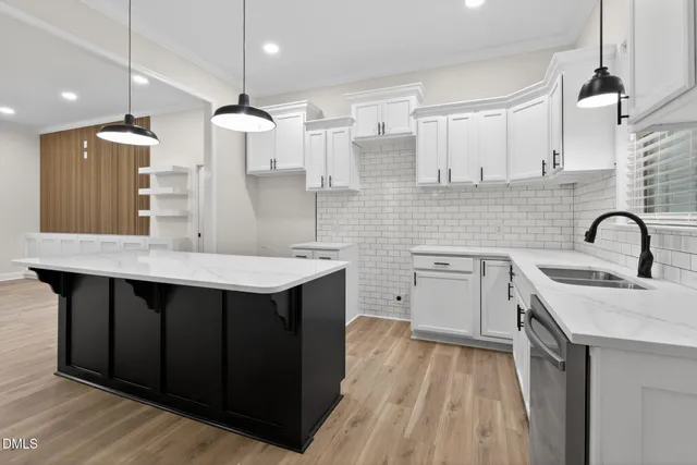a kitchen with a sink a counter space appliances and cabinets