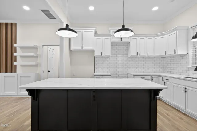 a kitchen with a sink a cabinets and wooden floor