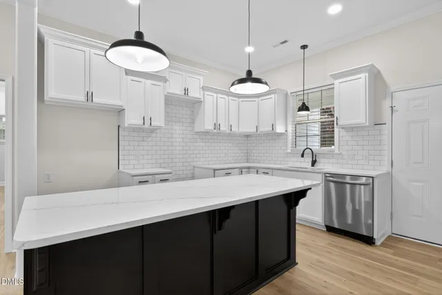 a kitchen with a sink a center island stainless steel appliances and cabinets