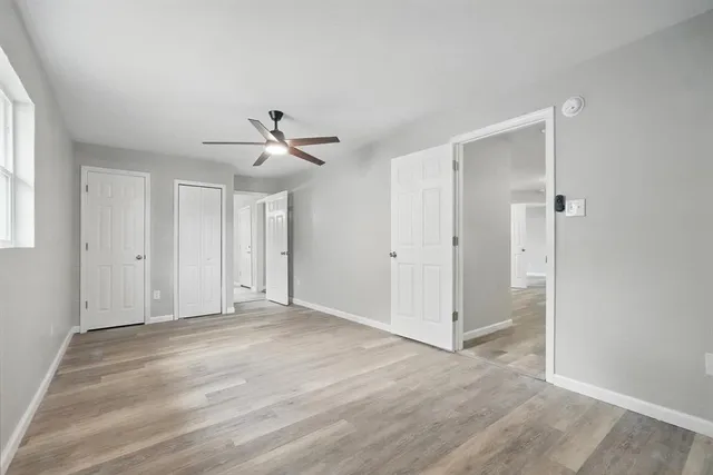 a view of a livingroom with a ceiling fan & entryway
