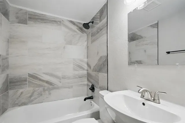 a bathroom with a sink shower and bathtub