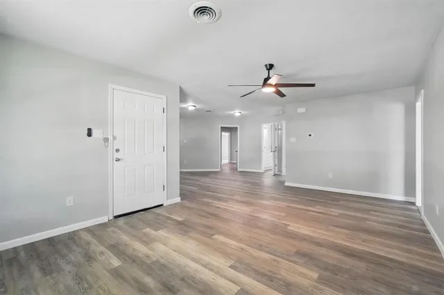 wooden floor in an empty room with a ceiling fan