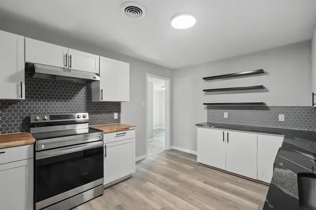 a kitchen with granite countertop a stove and a sink