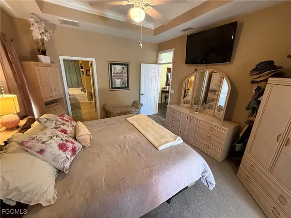 a bedroom with a bed a flat screen tv and a couch