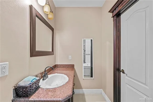 a bathroom with a granite countertop tub sink and mirror