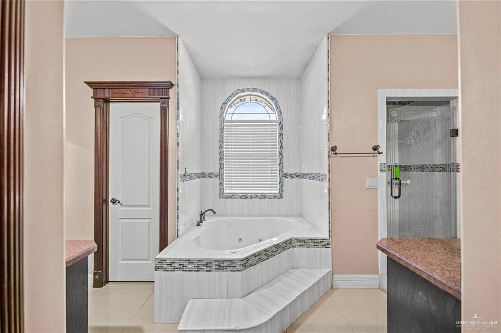 678 La Mesa Street Rio Grande City, TX 78582 - Photo 17 of 35 a bathroom with a granite countertop tub sink and mirror