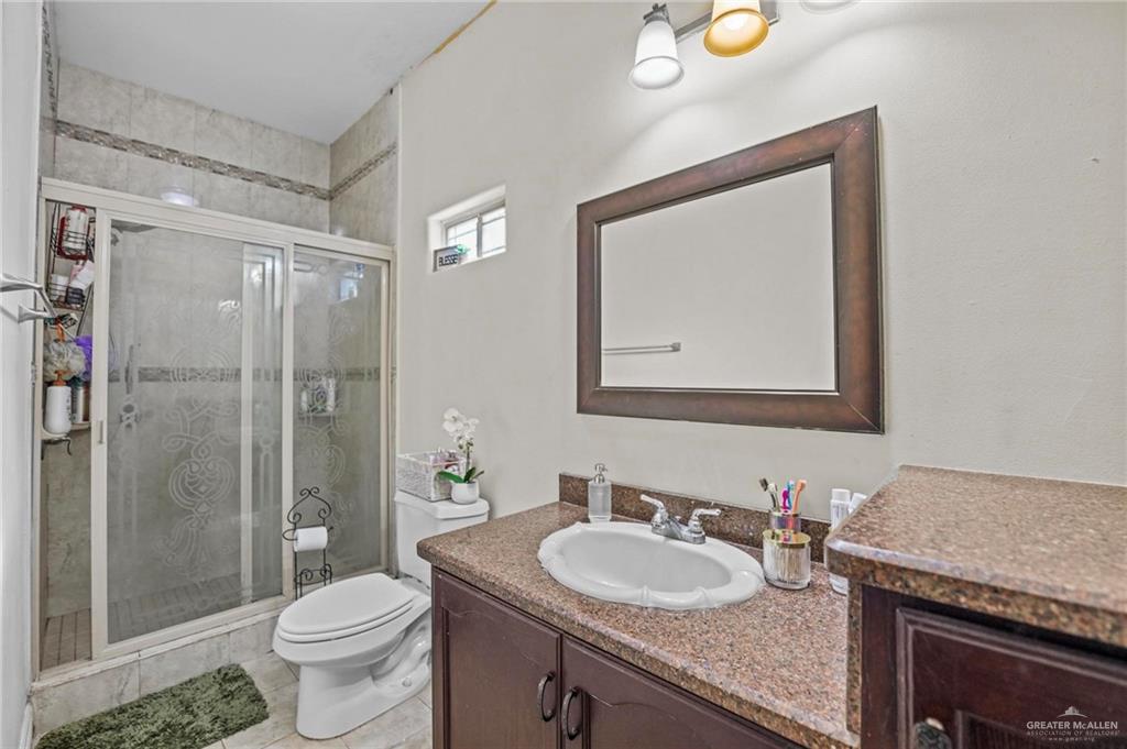 678 La Mesa Street Rio Grande City, TX 78582 - Photo 22 of 35 a bathroom with a granite countertop sink toilet and shower