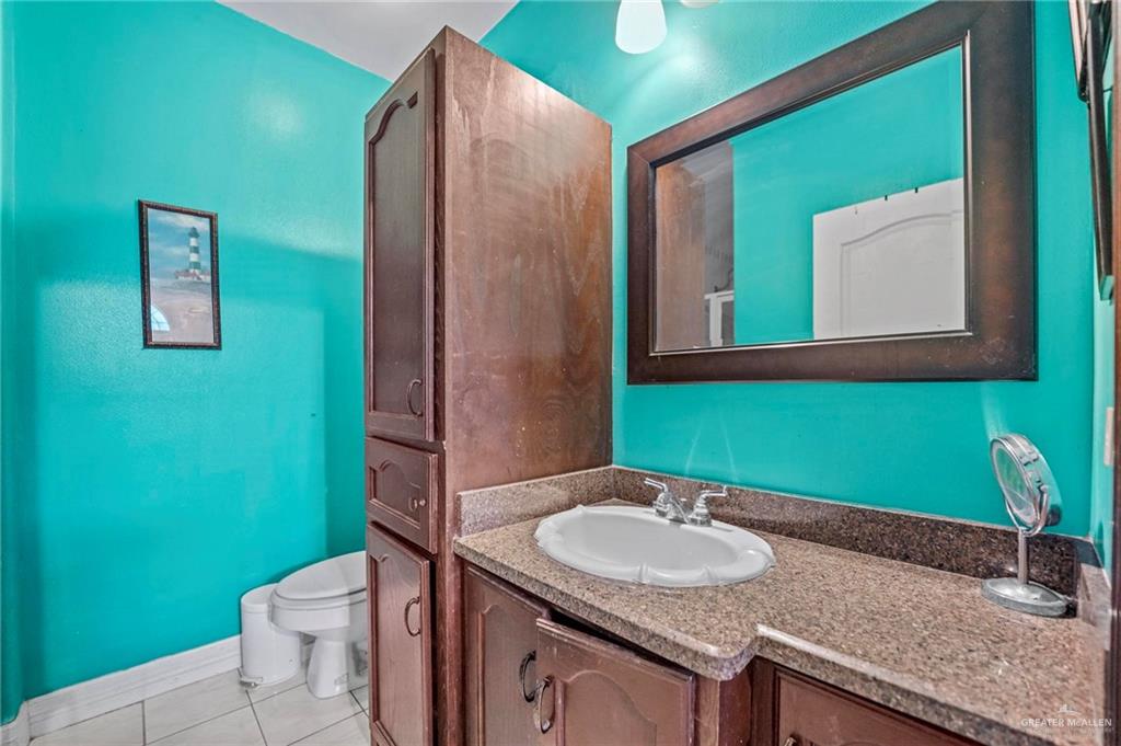 678 La Mesa Street Rio Grande City, TX 78582 - Photo 10 of 35 a bathroom with a granite countertop sink and a mirror