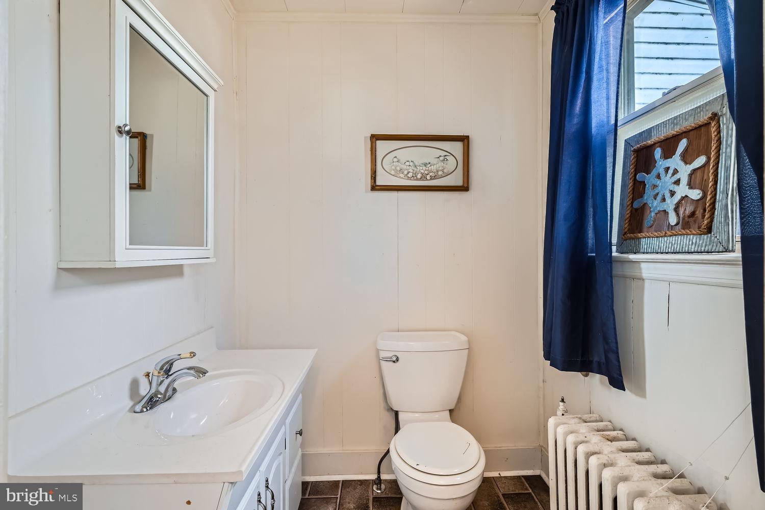 2328 Sparrows Point Road Sparrows Point, MD 21219 - Photo 11 of 28 a bathroom with a toilet a sink and mirror