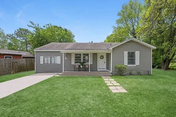 a front view of a house with a yard and trees