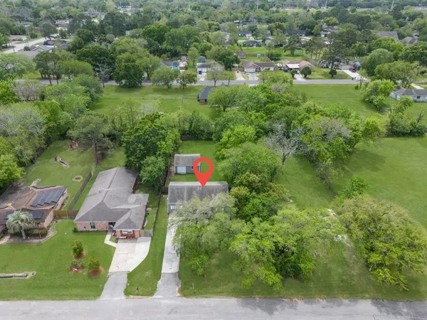 an aerial view of residential houses with outdoor space and trees