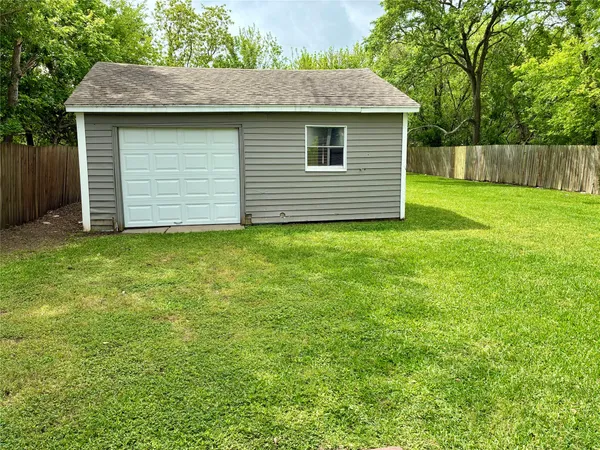 an empty room with a ceiling fan and window