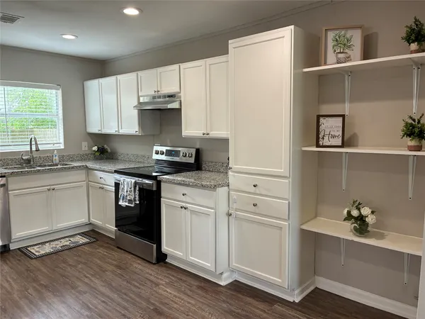a kitchen with a refrigerator and white cabinets