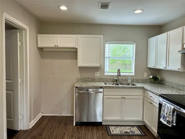 an empty room with a chandelier fan and windows