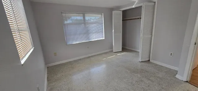 an empty room with windows and closet
