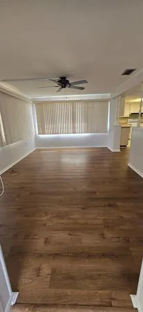 a view of empty room with wooden floor