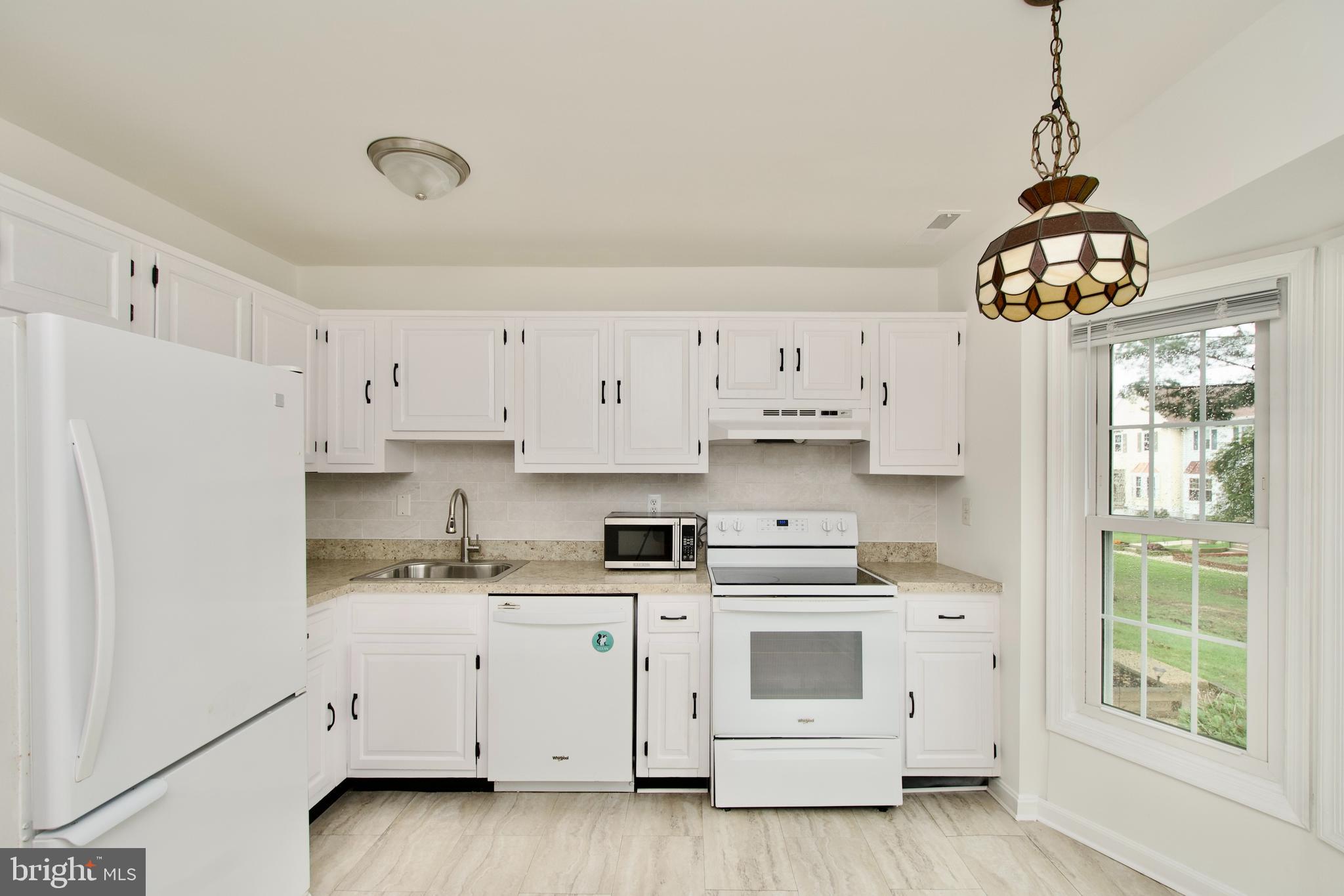 1448 Orleans Court Crofton, MD 21114 - Photo 12 of 33 a kitchen with stainless steel appliances white cabinets and a window