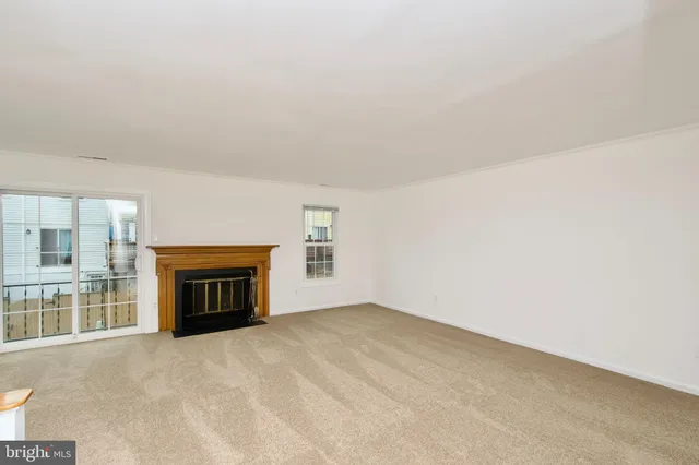 an empty room with fireplace and a window