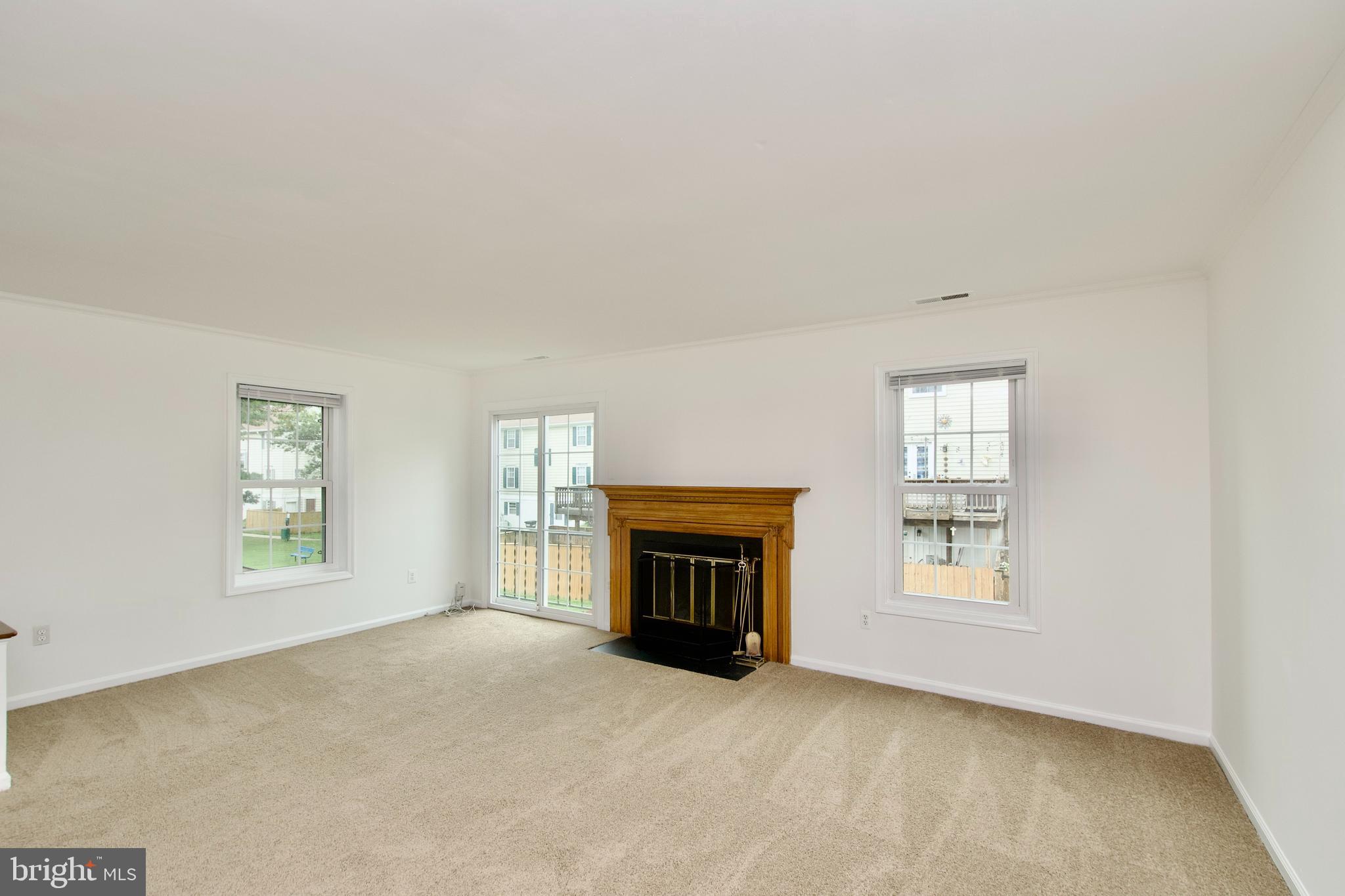 1448 Orleans Court Crofton, MD 21114 - Photo 9 of 33 an empty room with windows and fireplace