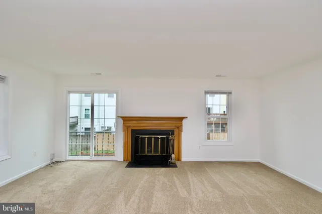an empty room with windows and fireplace