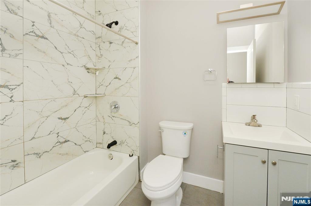 7 Watsessing Avenue, Unit 2R Bloomfield, NJ 07003 - Photo 11 of 14 a bathroom with a toilet sink vanity tub and mirror