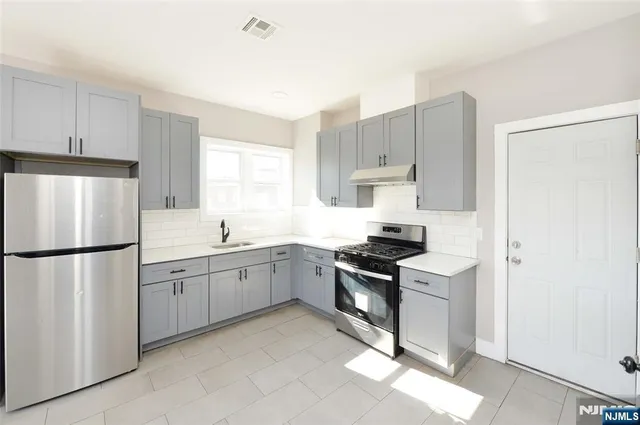 a kitchen with cabinets appliances and a window