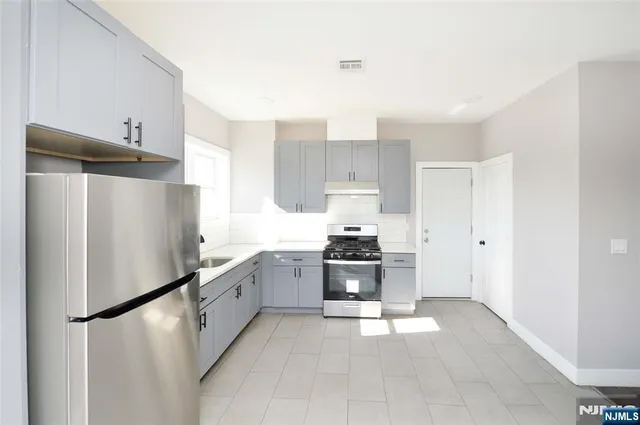a kitchen with stainless steel appliances a refrigerator sink and stove