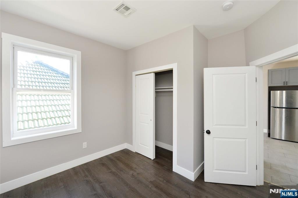 7 Watsessing Avenue, Unit 2R Bloomfield, NJ 07003 - Photo 6 of 14 a view of an empty room with wooden floor and a window