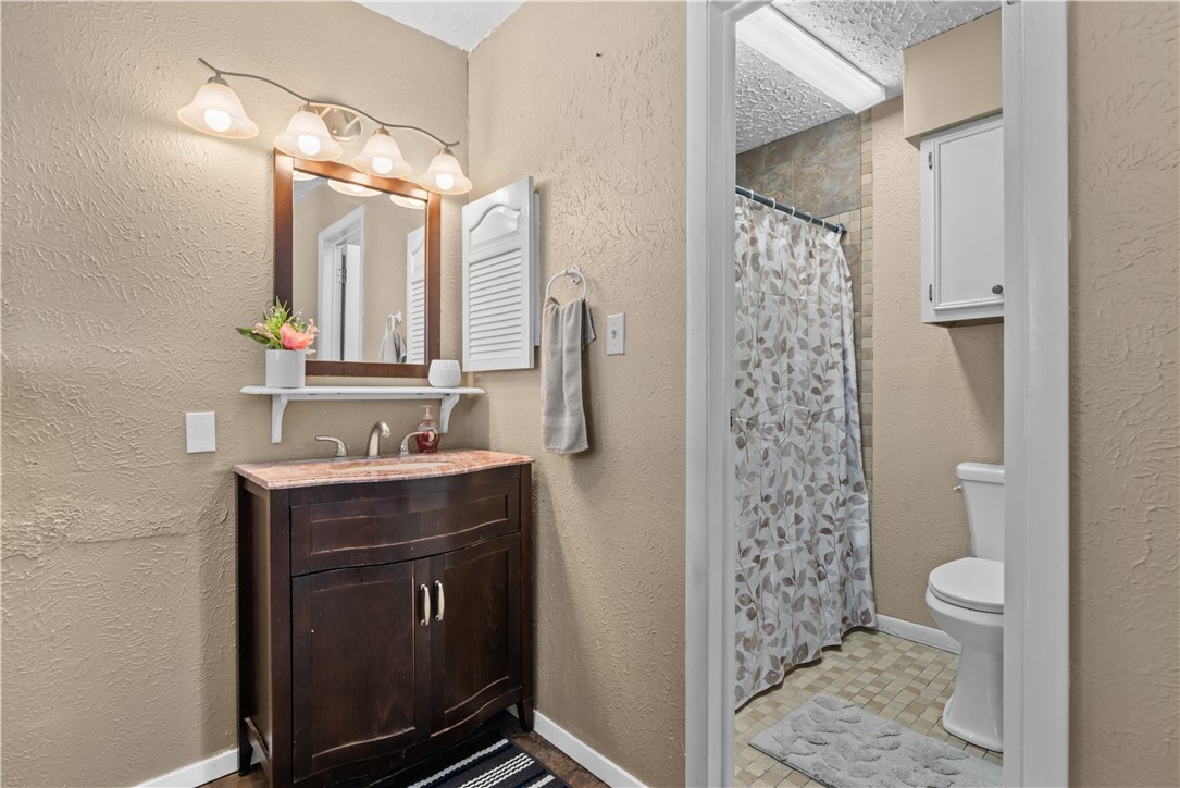 324 Stirrup Road Victoria, TX 77905 - Photo 23 of 40 a bathroom with a sink a toilet a mirror a vanity and shower
