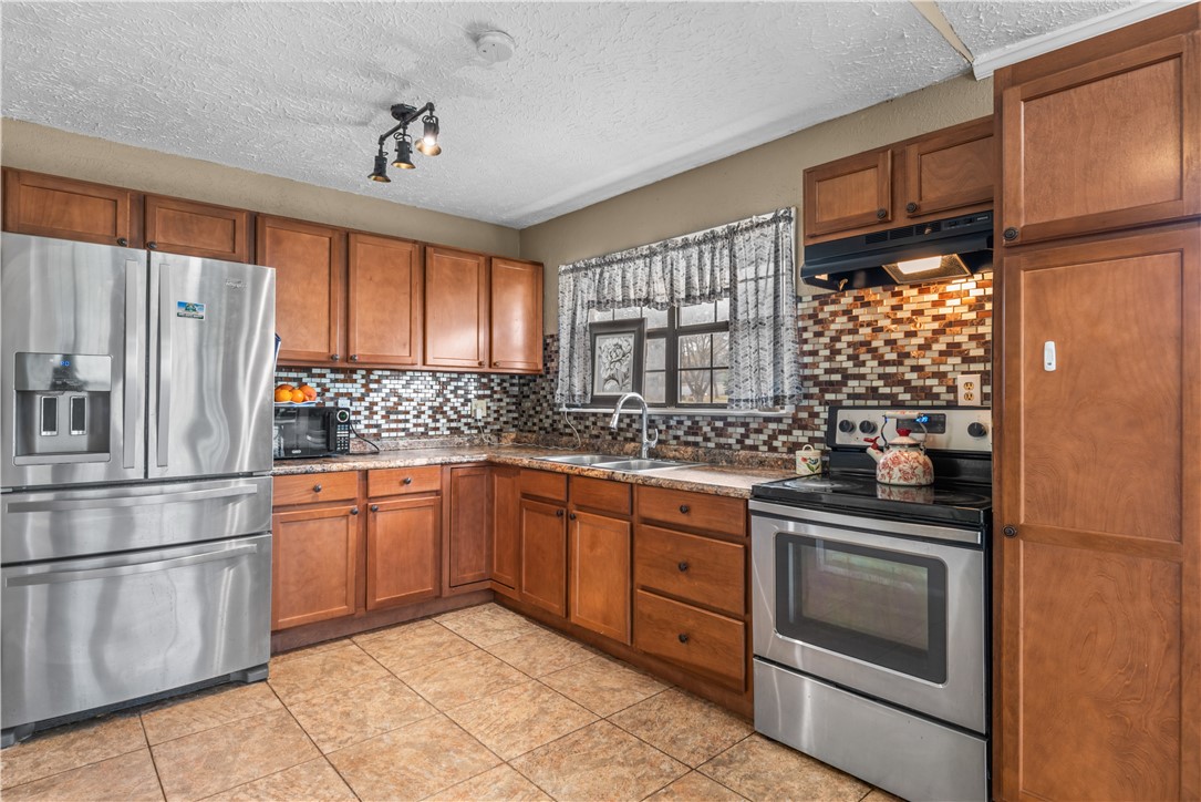 324 Stirrup Road Victoria, TX 77905 - Photo 7 of 40 a kitchen with granite countertop stainless steel appliances and wooden cabinets