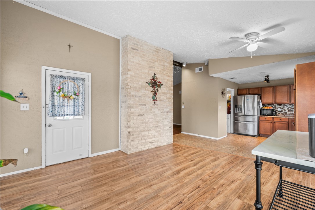 324 Stirrup Road Victoria, TX 77905 - Photo 10 of 40 a view of a livingroom with wooden floor and kitchen space with wooden floor